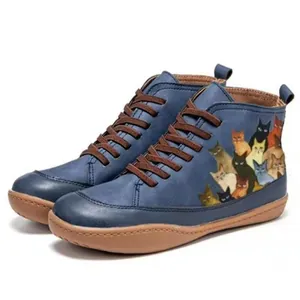 Detail view of vintage blue high-top boots featuring a colorful cat print illustration.