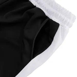 Close-up detail of elastic waistband and side pocket on black and white sweatpants
