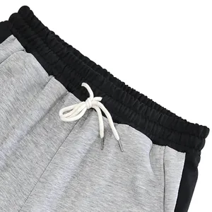 Detail view showing the elastic waistband and white drawstring of men's grey sweatpants