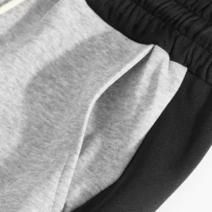 Detailed close-up of side pocket and elastic waistband on heavyweight color-block sweatpants