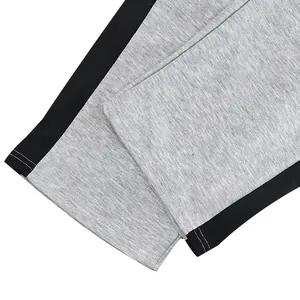 Close-up of heavy cotton sweatpants leg with straight hem and color block stripes.