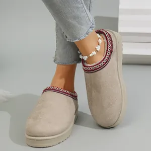 Detailed view of women's beige platform slippers with ethnic embroidery and warm fleece lining.
