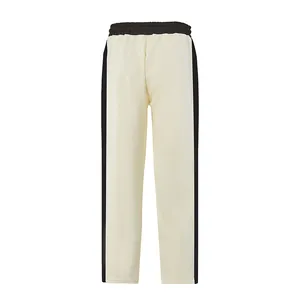Detail view of cream white men's sweatpants featuring bold black side stripes and waistband.
