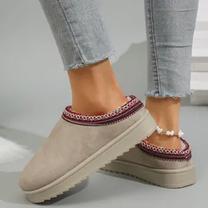 Detail view of stylish khaki suede snow boots featuring warm lining and red embroidered trim