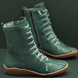 Detailed side view of teal leather ankle boots featuring unique lacing and side zipper