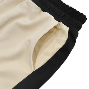 Macro detail of heavyweight men's sweatpants showing pocket and color-block stitching