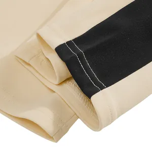 Detailed close-up of heavyweight sweatpants hem with black stripe and white stitching