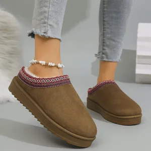 Close-up of warm brown winter mule slippers with thick sole and embroidered trim details