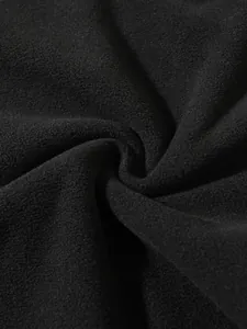Nahaufnahme der weichen und dichten Textur des schwarzen Korallenfleece-Stoffes
