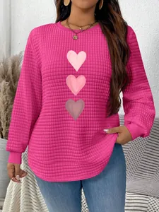 Detail view of pink heart print waffle knit sweatshirt with curved hem for women