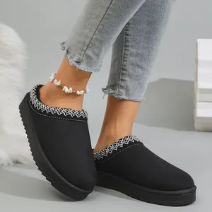 Close-up of black warm snow boots with white embroidery and thick soles
