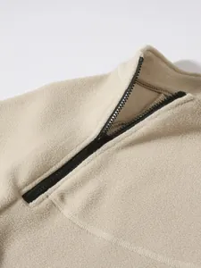 Close-up of the soft texture and black zipper on a men's half-zip fleece sweatshirt.