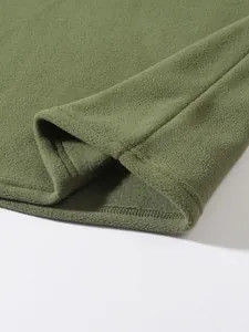 Nahaufnahme einer korallengrünen Fleecejacke mit weicher Textur und feiner Naht