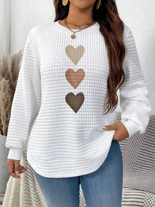 Close-up showing the waffle-knit texture and brown heart prints on this white sweatshirt