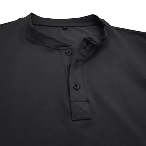 Detail van de knoopsluiting en kraag van een donkergrijs katoenen heren Henley shirt