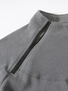 Close-up macro detail of grey men's fleece sweatshirt featuring a functional half-zip collar