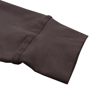 Close-up detail van de dubbelgestikte manchet van een bruin katoenen Henley-shirt met mouw