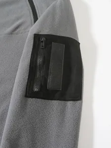 Detail view of tactical black sleeve pocket with zipper on grey fleece sweatshirt garment