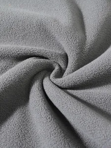 Macro view of soft grey coral fleece fabric showing its high-density fiber texture
