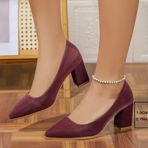 Detail shot of burgundy pointed-toe pumps with 7cm block heel on a model's feet