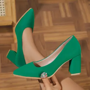 Close-up of emerald green pointed-toe chunky heel pumps in a professional French style