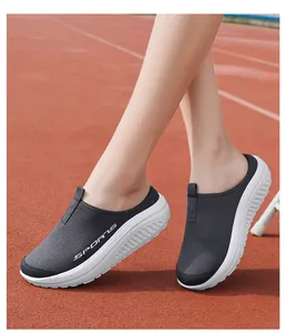 Primer plano de zapatillas tipo zueco de malla transpirable en una pista de atletismo.