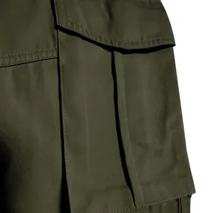 Close-up macro view of olive green cargo pant side pocket with durable flap stitching