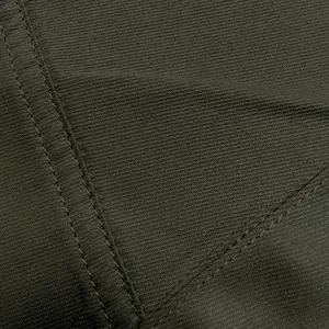 Close-up detail of olive green cargo pants fabric showing durable double stitching