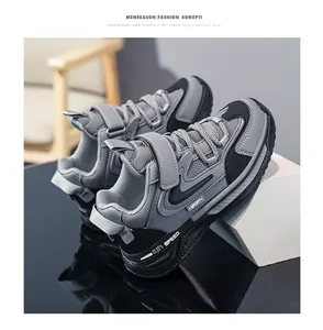Close-up detail of boys grey and black leather mesh sneakers with velcro strap closure