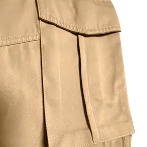 Macro detail of khaki cargo pants pocket showing heavy-duty stitching and twill fabric