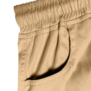 Macro detail shot showing the elastic waistband and side pocket of khaki cargo trousers