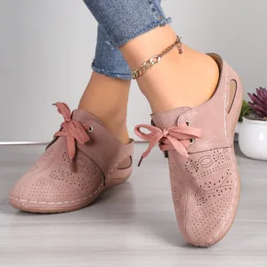 Close-up view of elegant dusty rose hollow-out lace-up wedge mules for women on model