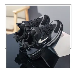 Close-up detail of black and grey boys' athletic sneakers featuring velcro straps.