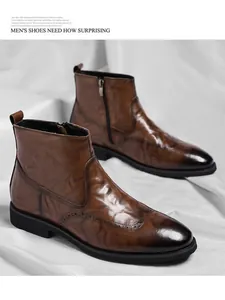 Detail view of brown vintage Chelsea boots with Brogue texture and side zipper.