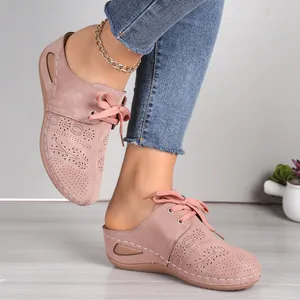 Stylish pink lace-up wedge mules for women featuring decorative floral hollow-out patterns
