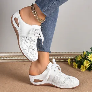 Detail shot of white lace-up hollow-out wedge mule sandals with decorative anklet