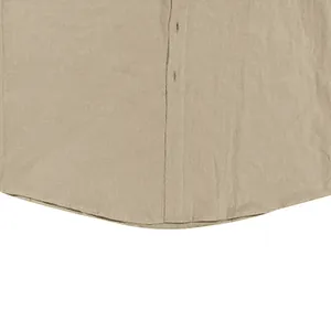 Détail rapproché de la texture du tissu et de l'ourlet incurvé d'une chemise en lin kaki