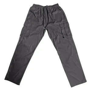 Detail of grey men's cargo pants with drawstring waist and multiple functional pockets.