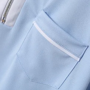 Detailansicht eines blauen Polohemds mit Brusttasche und Reißverschluss-Detail