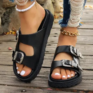 Detail von schwarzen Plateau-Sandalen mit dekorativen silbernen Schnallen im Western-Stil