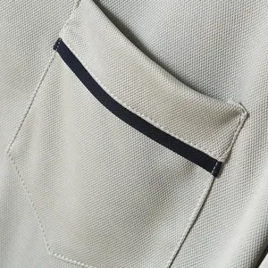 Detaillierte Makroansicht des atmungsaktiven Polo-Hemd-Stoffs und Brusttaschen-Designs