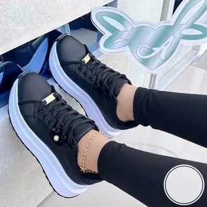 Close-up of black platform sneakers with thick white soles and gold accents