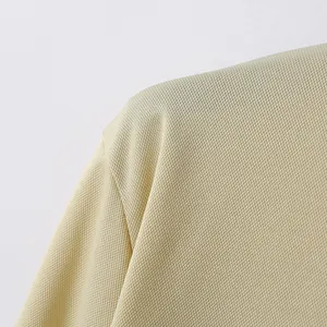 Nahaufnahme eines beigen Polo-Shirts mit atmungsaktiver Waffelpikee-Gewebe-Struktur
