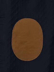 Detail shot of the brown oval elbow patch on a navy heavy jacquard knit men's sweatshirt