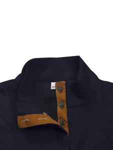 Detailaufnahme eines dunkelblauen Herren-Henley-Shirts mit braunem Kontrastkragen.
