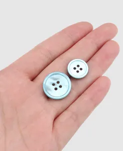 Close-up macro of premium iridescent light blue shell buttons with four-hole circular design