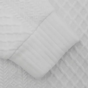 Nahaufnahme der schweren weißen Jacquard-Struktur und des Rippbündchens eines Herren-Hoodies.