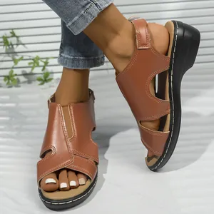 Detailansicht brauner Römersandalen mit Kontrastnähten und einem klobigen Absatz.