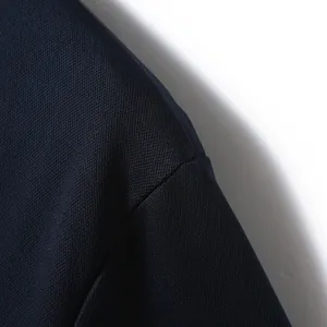 Nahaufnahme des marineblauen Piqué-Stoffes und der Schulternaht eines Poloshirts