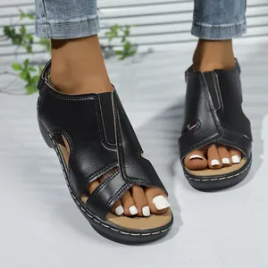 Detailaufnahme von schwarzen Sandalen mit Klettverschluss und Ziernähten.